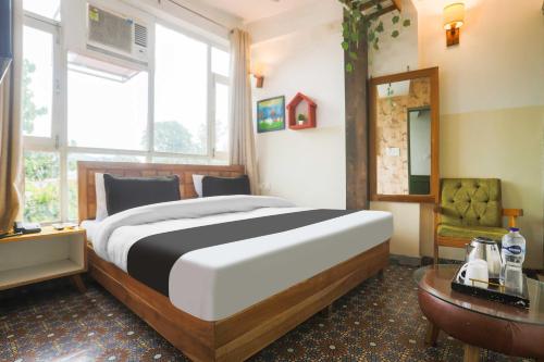 a bedroom with a large bed and a table at Hotel O Pacific Mall Rajpur Road in Dehradun