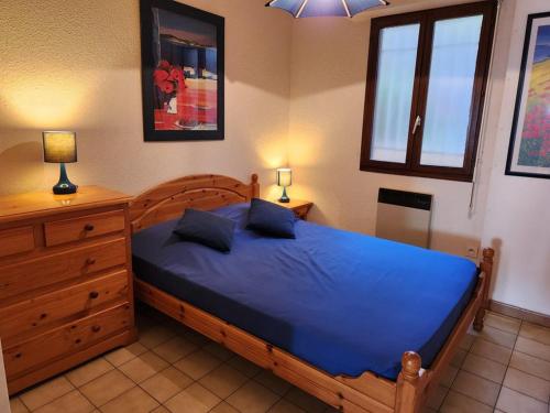 - une chambre avec un lit bleu et une commode dans l'établissement Le Lavandou T2 pour 4 personnes avec terrasse, vue mer, parking - FR-1-803-36, au Lavandou