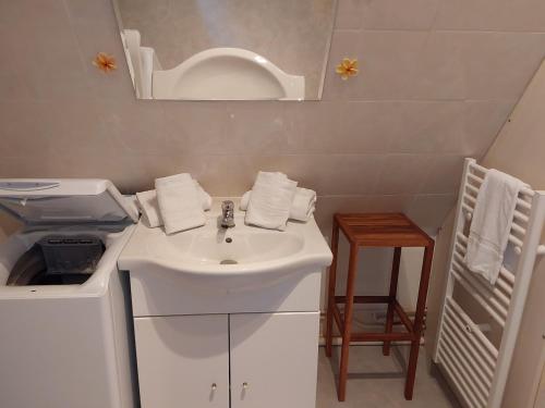 a white bathroom with a sink and a mirror at L'écluse appartement vue sur mer in Port-en-Bessin-Huppain