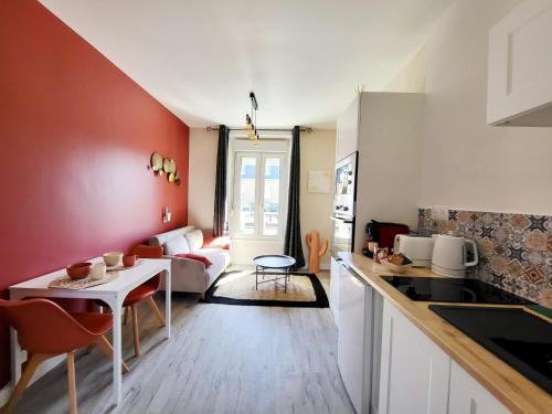 a kitchen and living room with a table and a couch at Hacienda -A 2 min de la plage in Saint Malo