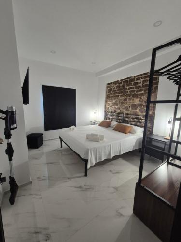 a bedroom with a bed and a brick wall at The Stone Loft Cuccureddu in Lotzorai