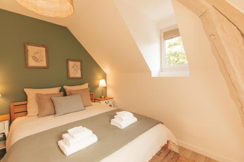 une chambre avec un lit avec des serviettes blanches dessus dans l'établissement Appartement dans Manoir avec piscine face au Golf d'Uriage, à Vaulnaveys-le-Haut