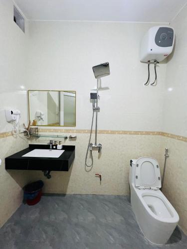 a bathroom with a toilet and a sink and a mirror at Peaceful Mountain Hotel in Ha Giang