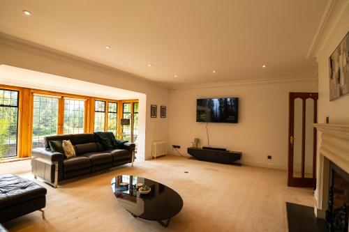 a living room with a couch and a fireplace at Chimneys Hot Tub Country Escape in Stourbridge