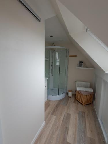 une salle de bain avec douche en verre dans un grenier dans l'établissement Les Mollières, au Crotoy