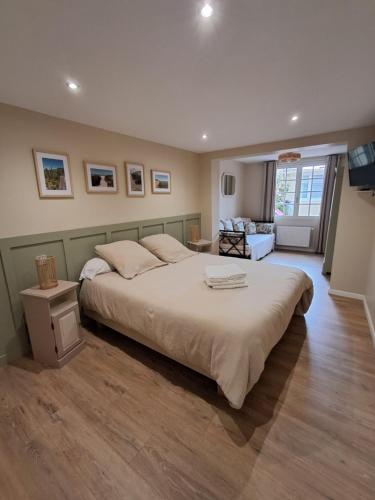 une chambre avec un grand lit et un salon dans l'établissement Les Mollières, au Crotoy