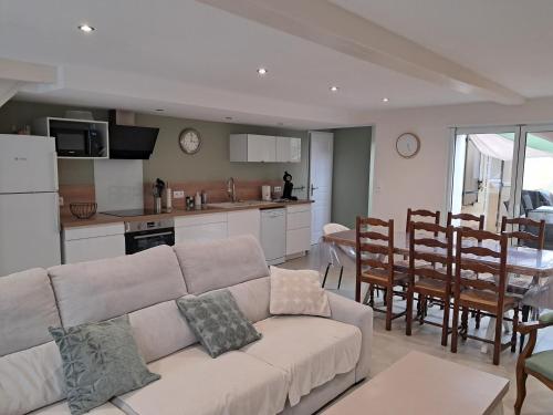 un salon avec un canapé et une cuisine dans l'établissement Les Mollières, au Crotoy