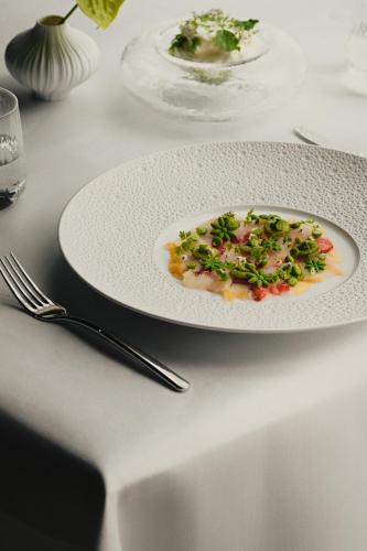 a plate of food on a table with a fork at Hotel Blow Up Hall in Poznań