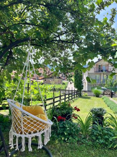 a hammock hanging from a tree in a garden at Rustična kuća CRVENA STENA u blizini kućice na Drini in Bajina Bašta