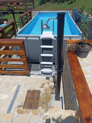 a pool with a hot tub next to a wooden fence at Rustična kuća CRVENA STENA u blizini kućice na Drini in Bajina Bašta
