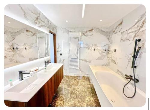 une salle de bain avec deux lavabos et une baignoire dans l'établissement Villa Riviera, à La Celle-sous-Gouzon