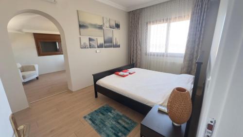 a bedroom with a bed and a chair and a window at villamonda in Kızilbahçe