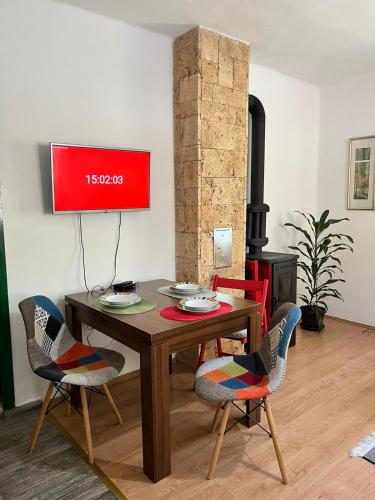 a dining room with a table and chairs and a stove at Rustična kuća CRVENA STENA u blizini kućice na Drini in Bajina Bašta