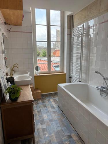 une salle de bain avec une baignoire, des toilettes et un lavabo dans l'établissement Maison familiale en centre-ville, à Rochefort