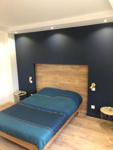 - une chambre avec un lit bleu et 2 tables dans l'établissement Appartement plein centre ville, à Boulogne-sur-Mer
