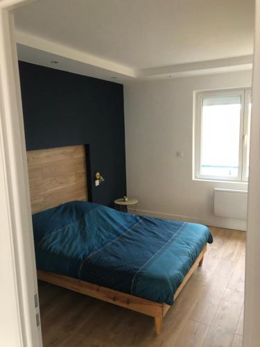 une chambre avec un lit bleu et une fenêtre dans l'établissement Appartement plein centre ville, à Boulogne-sur-Mer