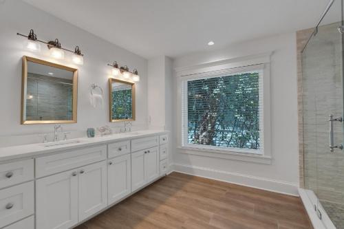 a white bathroom with two sinks and a shower at Sunset Splash in Siesta Key