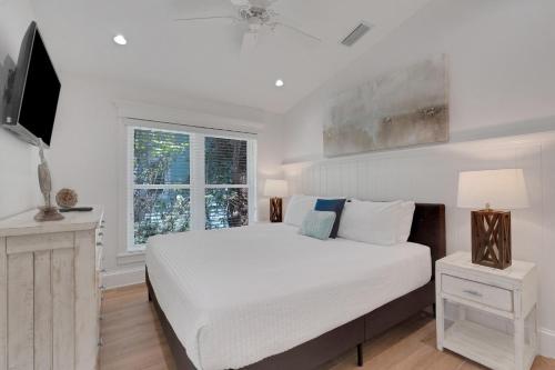 a white bedroom with a bed and a window at Sunset Splash in Siesta Key
