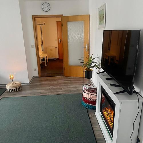 a living room with a flat screen tv and a fireplace at Ferienwohnung in Geislingen an der Steige