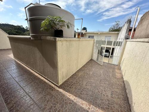 ein Pflanzkübel an einer Wand mit einer Pflanze darauf in der Unterkunft Casa Sta Amélia 3 quartos, 3 banheiros c/ garagem in São Roque