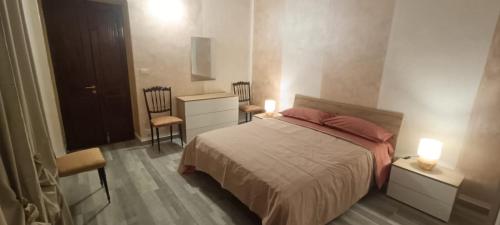 a bedroom with a bed and a nightstand and two lamps at A ca' vostra in Villanova dʼAsti