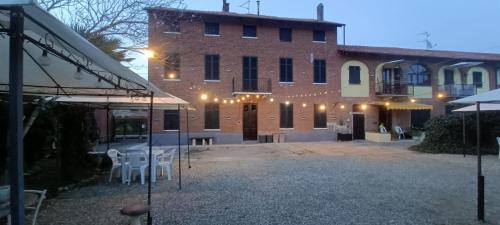 a large brick building with white chairs in front of it at A ca' vostra in Villanova dʼAsti