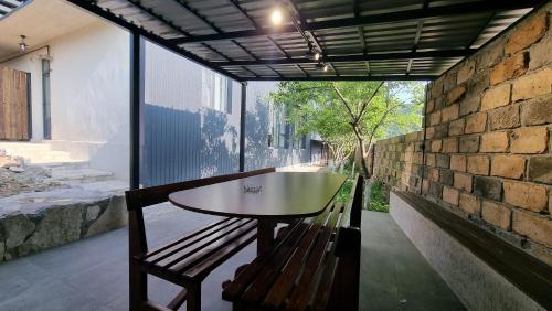 a table and a bench on a balcony with a brick wall at Chill out Zone , villa with 4 bedrooms, whole apartment, апартамент целиком in Dilijan