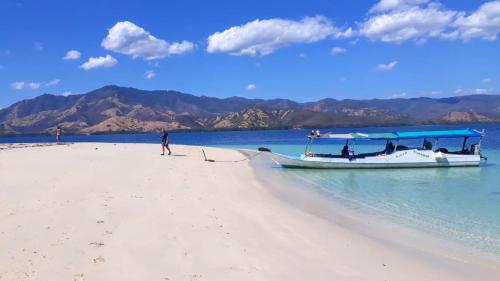 a boat on a beach with a person on it at All-Inclusive Paradise Experience - Boat Tour, Snorkeling & Island Camping 
