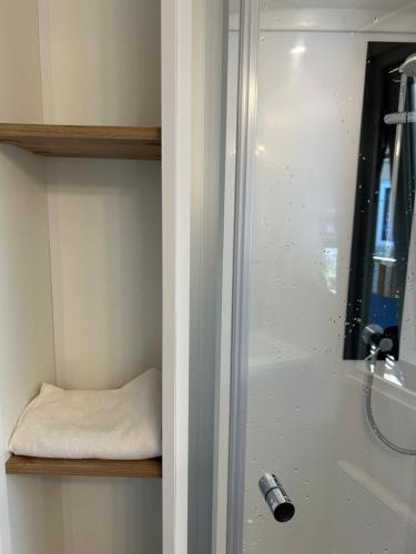 une salle de bain avec une douche avec un lavabo et une baignoire dans l'établissement Mobilhome Landes Les Dunes de Contis, à Saint-Julien-en-Born