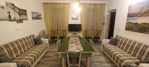 a living room with couches and a table and a tv at A ca' vostra in Villanova dʼAsti