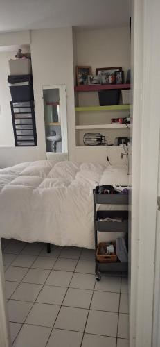 une chambre avec un lit blanc et un miroir dans l'établissement rez de chaussée de villa, à La Colle-sur-Loup