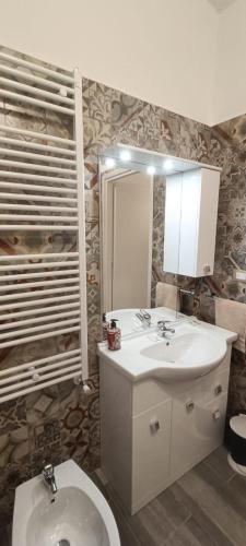 a bathroom with a sink and a toilet and a mirror at A ca' vostra in Villanova dʼAsti
