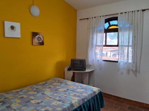 ein Schlafzimmer mit einem Bett und einem Fenster in der Unterkunft Aconchegante casa à beira da praia in Maricá