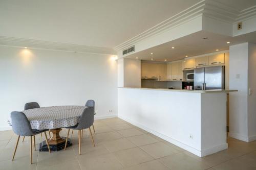une salle à manger avec une table et des chaises et une cuisine dans l'établissement Appartement vue mer Cannes, à Cannes