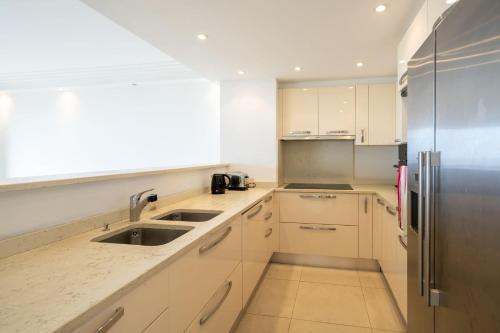 une cuisine avec des armoires blanches et un réfrigérateur en acier inoxydable dans l'établissement Appartement vue mer Cannes, à Cannes