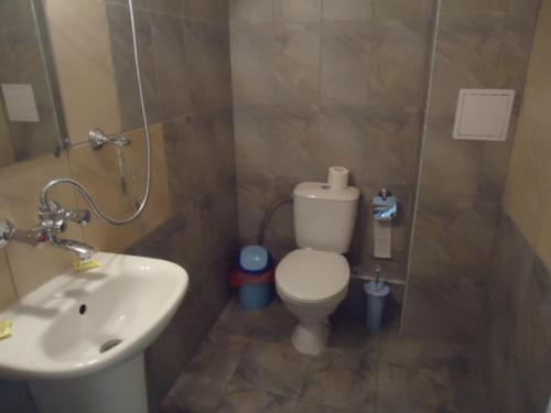 a bathroom with a white toilet and a sink at Тихия кът in Sozopol