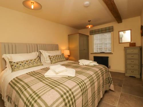 een slaapkamer met een bed met twee handdoeken erop bij Bridge House Cottage in Harrogate