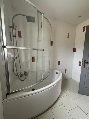 a bathroom with a tub and a glass shower at Chez Marie et Fabrice in La Marque