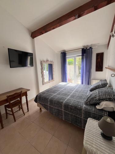 une chambre avec un lit, une table et une fenêtre dans l'établissement Maison grand confort Port Camargue LE GRAU DU ROI proche ESPIGUETTE, au Grau-du-Roi