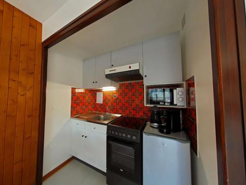 Il comprend une petite cuisine équipée d'une cuisinière et d'un évier. dans l'établissement Superbe studio 4 pers au Grand-Bornand avec balcon, navette proche - FR-1-241-245, au Grand-Bornand