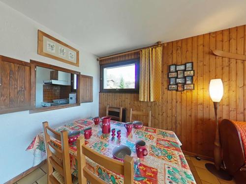- une salle à manger avec une table et des tasses rouges dans l'établissement Grand-Bornand Appt 6 pers. 2 chambres - Navette ski, Cheminée, Ménage inclus - FR-1-241-62, au Grand-Bornand
