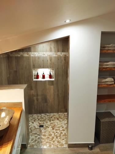 La salle de bains en bois est pourvue d'une douche à l'italienne. dans l'établissement Maison du Troubadour, à Balazuc