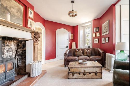 a living room with a couch and a fireplace at East Lodge - Chillingham Castle in Alnwick