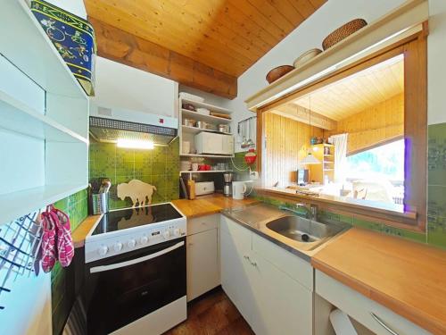 une cuisine avec un évier et une cuisinière dans l'établissement Bel Appt 2P avec mezzanine, parking à 900m du centre - FR-1-241-101, au Grand-Bornand