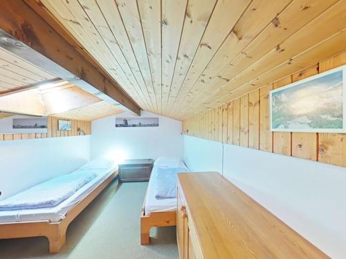 Cette chambre dispose de deux lits et d'un plafond en bois. dans l'établissement Bel Appt 2P avec mezzanine, parking à 900m du centre - FR-1-241-101, au Grand-Bornand