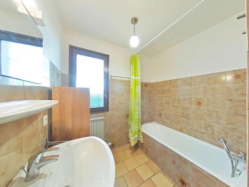 une salle de bain avec une baignoire et un lavabo dans l'établissement Grand-Bornand Appt 6 pers. 2 chambres - Navette ski, Cheminée, Ménage inclus - FR-1-241-62, au Grand-Bornand