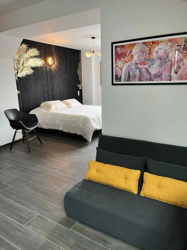 une chambre avec un lit, une chaise et un canapé dans l'établissement Grange&Lodge, à Chavelot