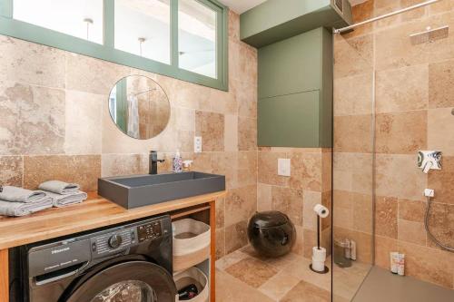 une salle de bain avec une machine à laver et un lavabo dans l'établissement OWL PRESTIGE Dijon, à Dijon