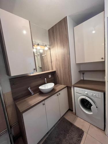 une salle de bain avec un lavabo et une machine à laver dans l'établissement Maison grand confort Port Camargue LE GRAU DU ROI proche ESPIGUETTE, au Grau-du-Roi