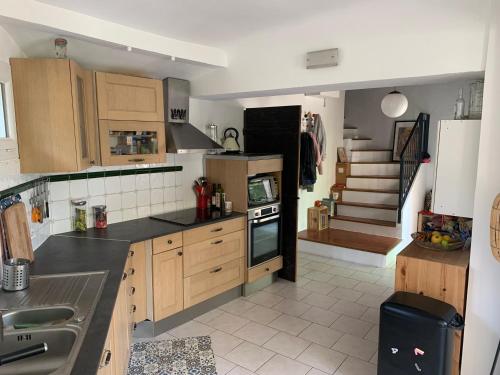 une cuisine avec des placards en bois et un escalier dans l'établissement Maison en campagne aixoise, à Aix-en-Provence